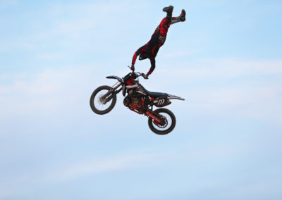 motorcycle in air with rider doing stunts